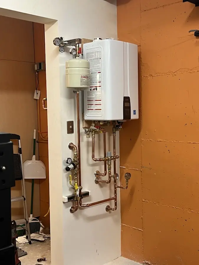 Plumbing technician inspecting water heater connections in Oxon Hill